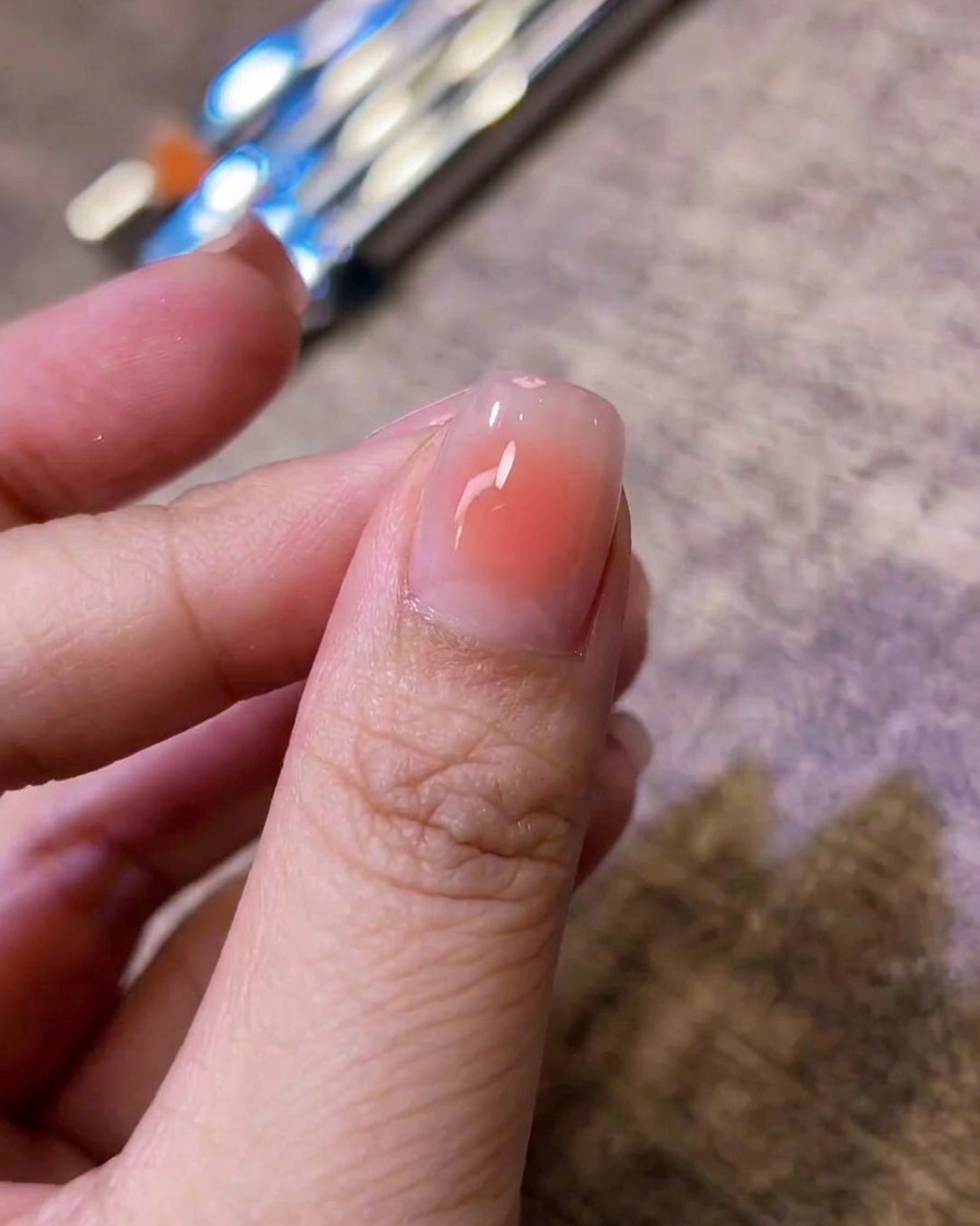 Uña brillante con un centro difuminado en tono rosa blush sobre una base nude.