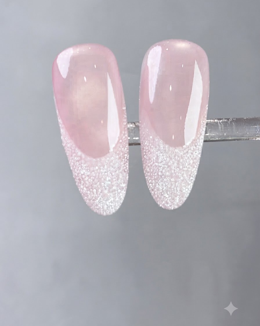 Un pincel aplicando una capa de gel blanco lechoso fluido sobre una uña natural.
