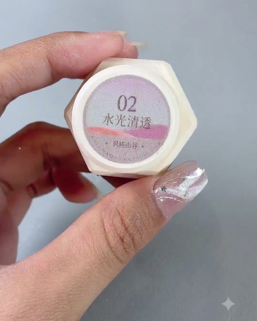 Un par de manos sosteniendo un frasco de esmalte de gel ojo de gato traslúcido número 2.
