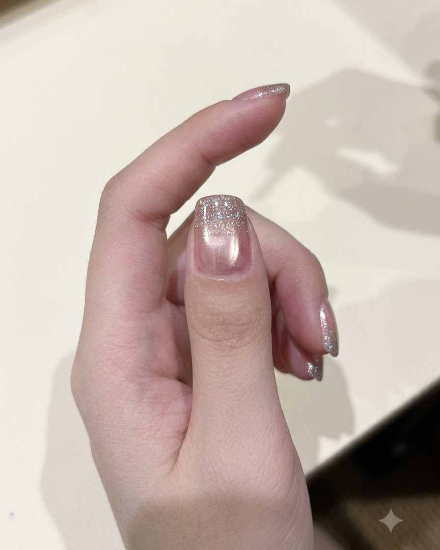 Un pincel de esmalte aplicando una capa de gel con purpurina de diamante brillante sobre una uña curada.