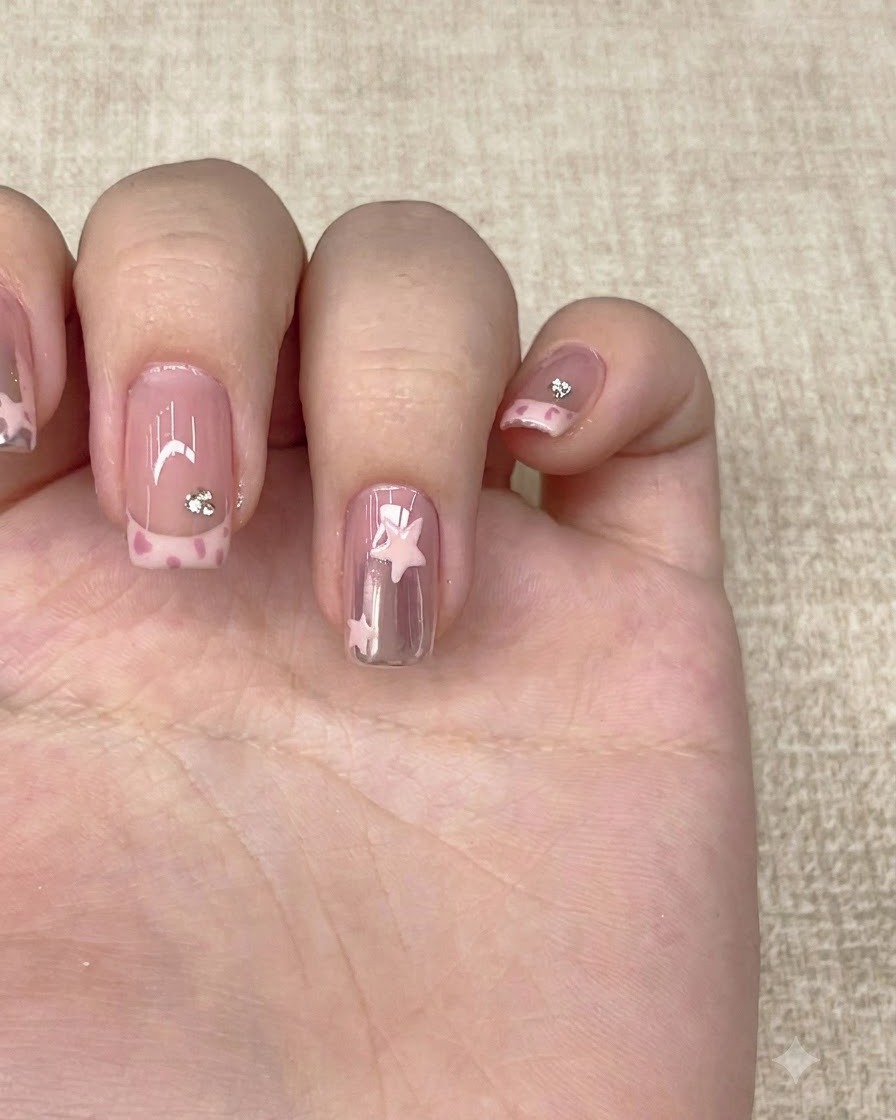 Un pincel de capa superior transparente dando el acabado a una mano manicurada completa con arte en las uñas.