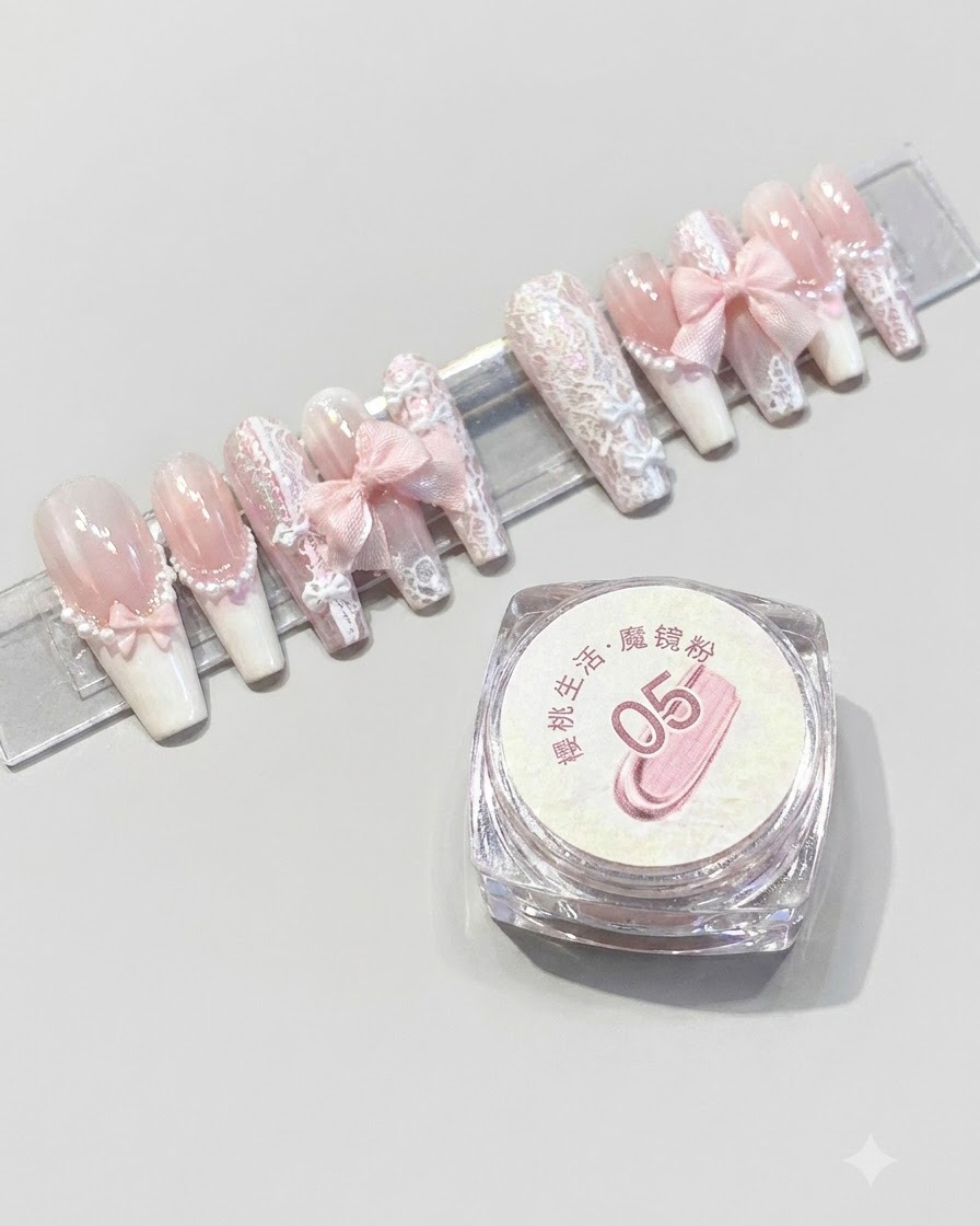 Un envase de polvo espejo mágico Cherry Life número 05 colocado junto a un expositor de uñas postizas rosas terminadas.
