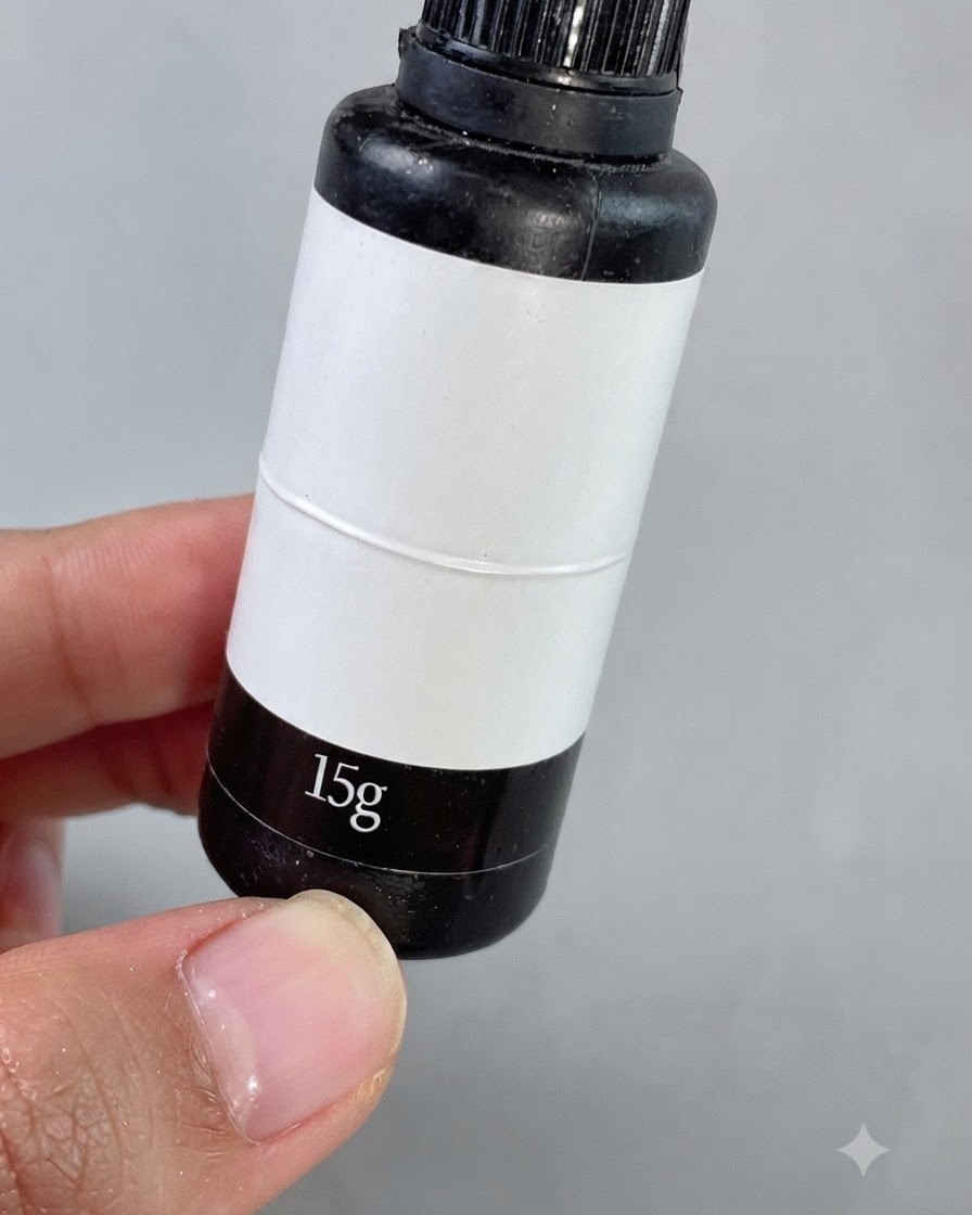 Un pincel de detalles finos aplicando gel rellenador transparente alrededor de pequeños diamantes cuadrados en una uña manicurada.