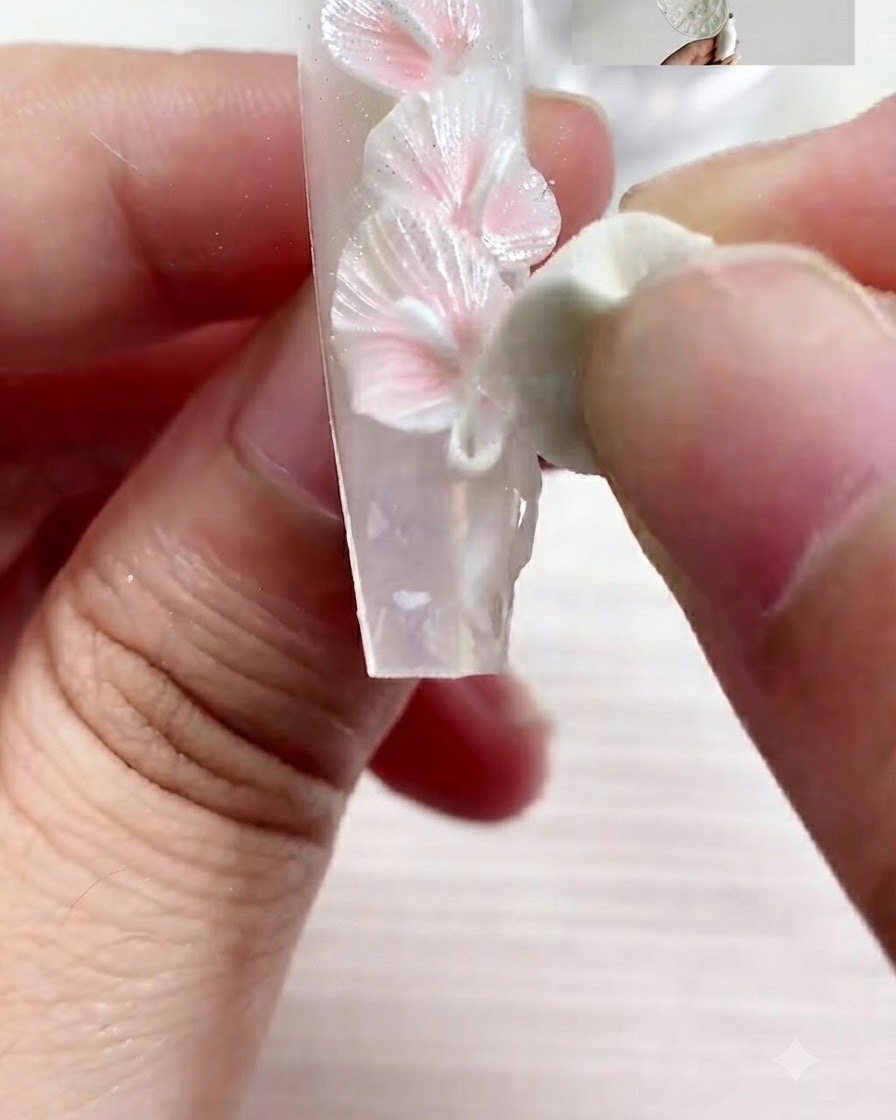 Un pincel fino aplicando detalles precisos con gel S01 sobre la uña decorada.