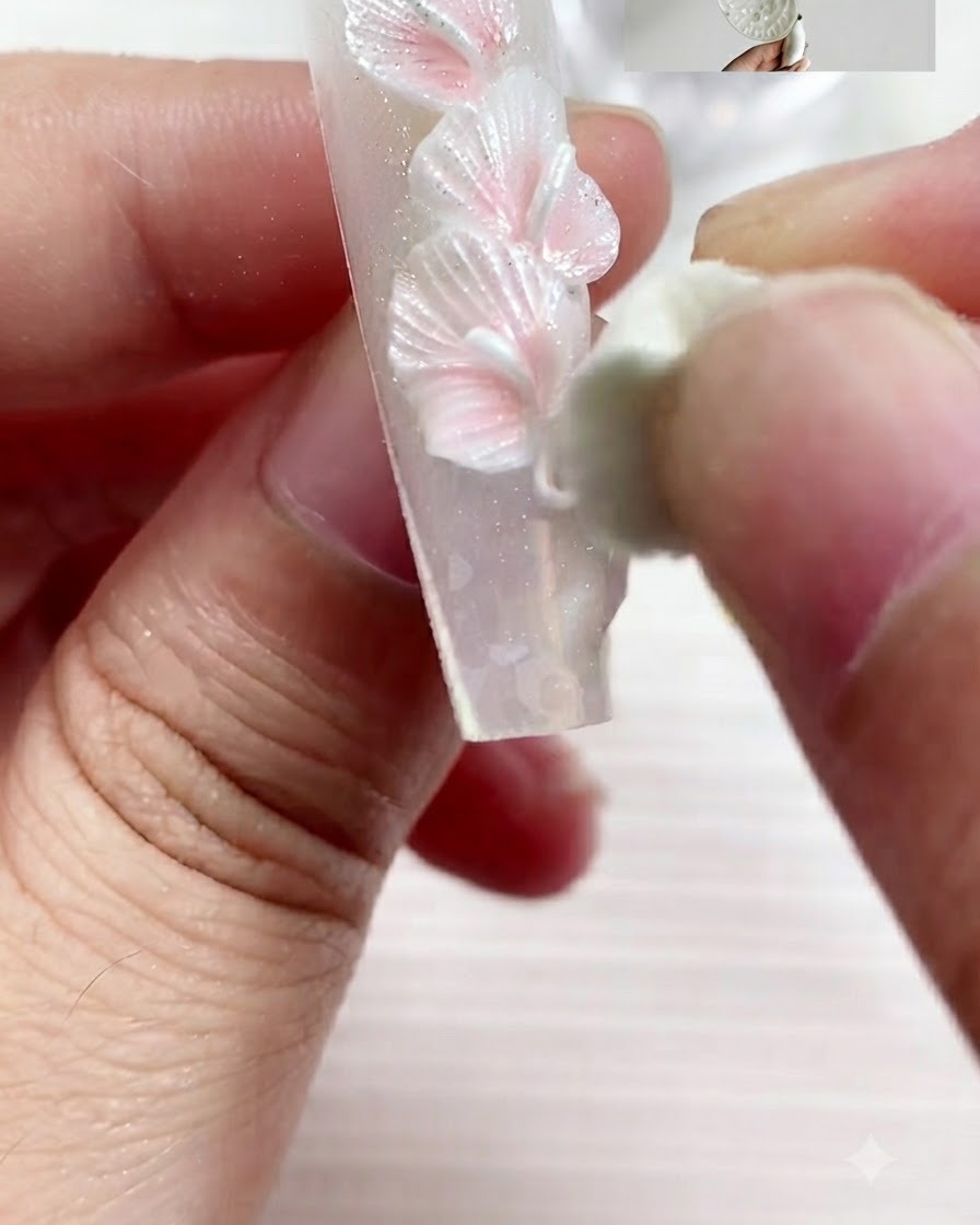 Una herramienta de esculpido presionando y moldeando una pieza de gel para formar un pétalo de lirio calla aplanado.