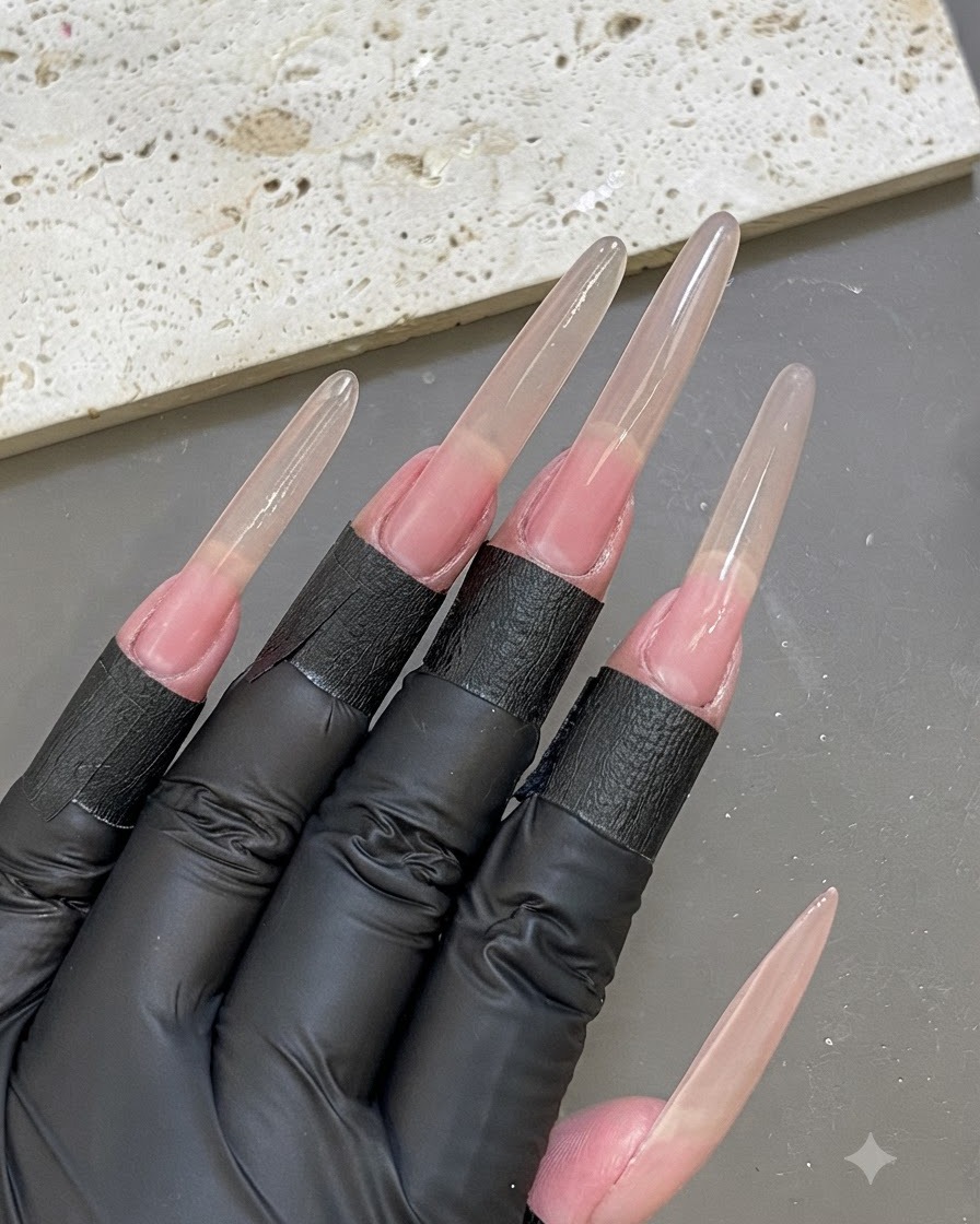 Una vista superior de una mano con formas de extensión de uñas idénticas aplicadas en todos los dedos.