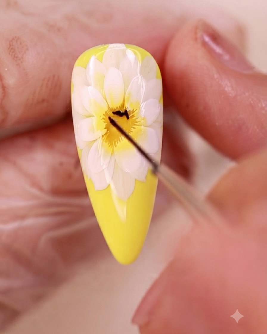 Un pincel delineador fino dibujando líneas finas negras en el centro del arte de uñas floral.