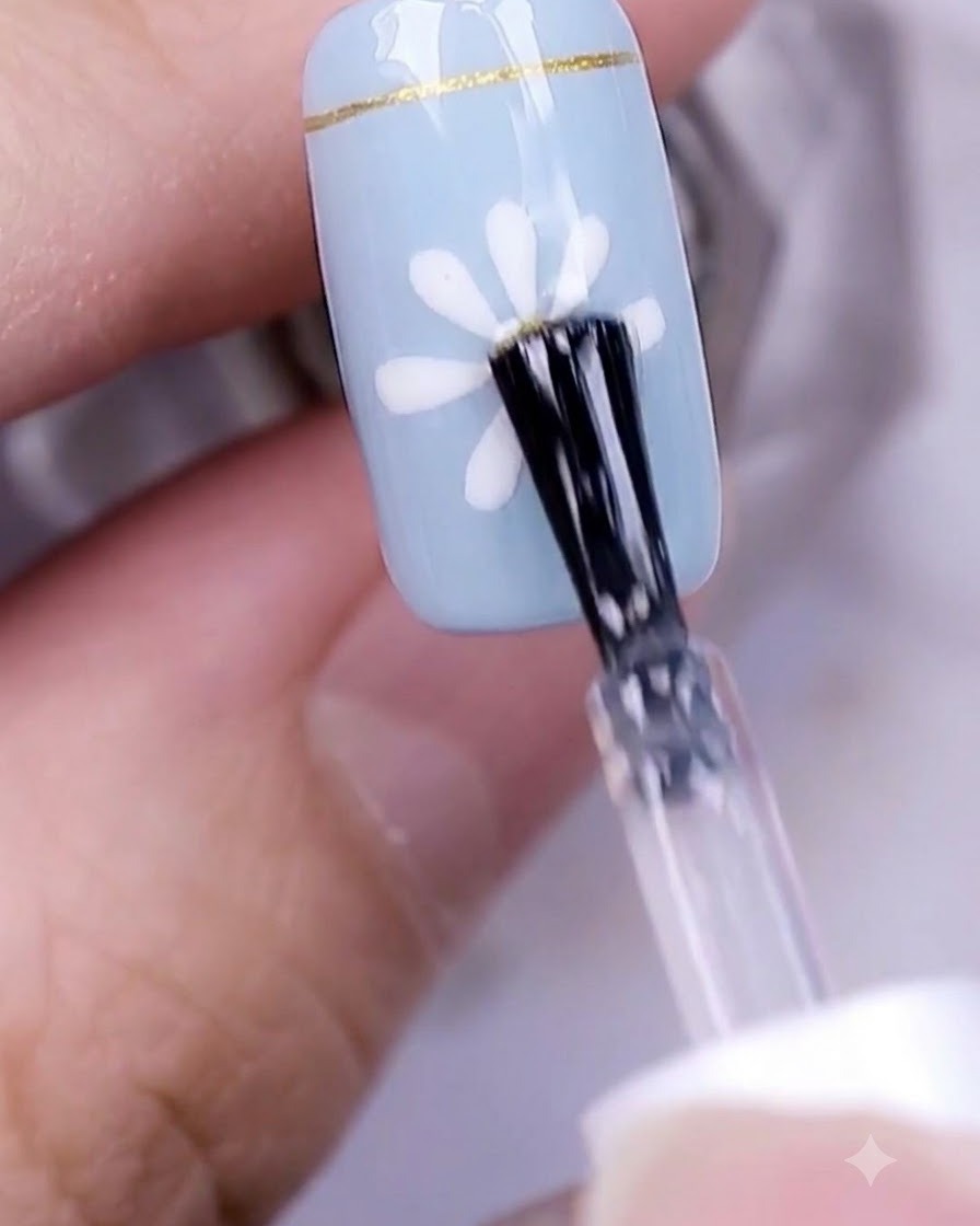Una mano con un diseño de uñas de margarita terminado curando bajo una lámpara UV profesional.