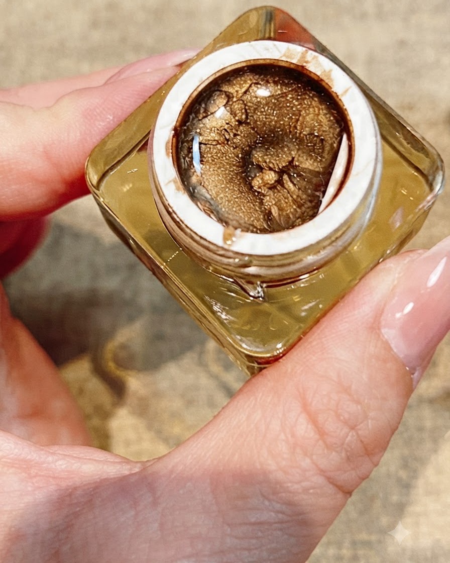 Una herramienta colocando un pequeño pedrería brillante al lado de una rosa pintada y finalizada en una uña.