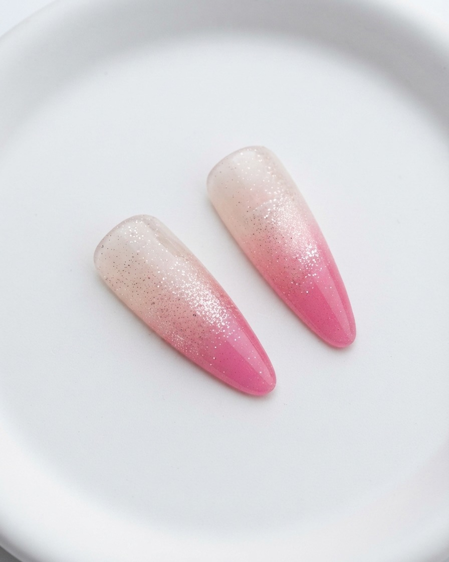 Uñas curándose bajo una lámpara UV después de la segunda capa rosa.