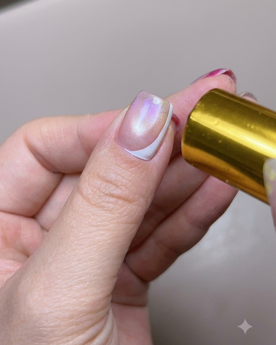 Una uña de pulgar con una punta francesa lateral blanca curada siendo expuesta a una luz de curado.
