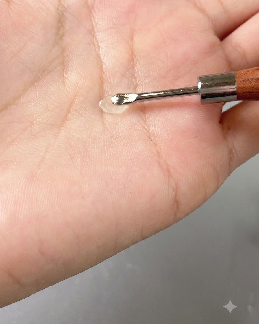 Una pequeña porción de gel transparente descansando sobre una herramienta de mano contra la palma.