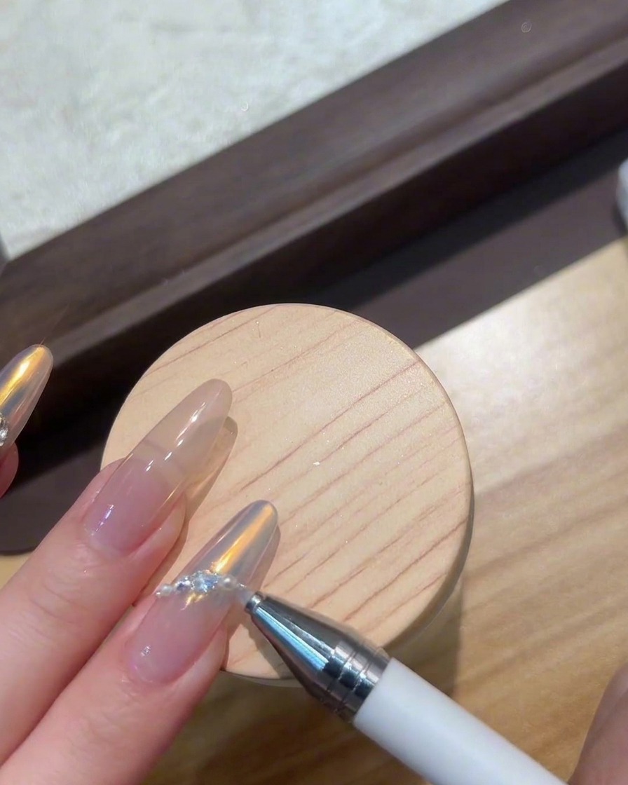 Dedos colocados bajo una lámpara UV/LED compacta curando gemas de arte en uñas.