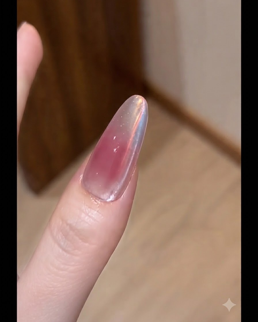 Un pincel plano aplicando una capa fina de gel de color nude sobre una uña esculpida.