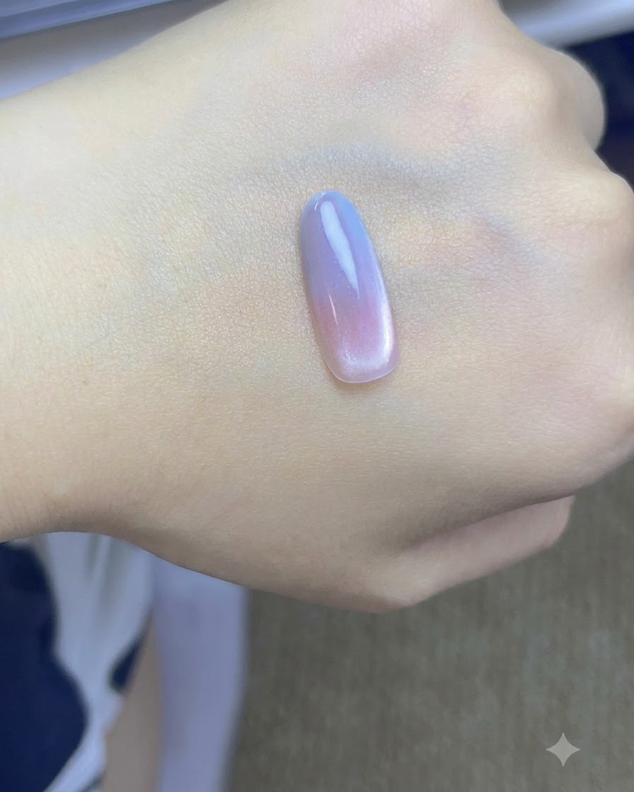 Un pincel aplicando a pequeños toque una segunda capa de gel azul en la punta de la uña sobre una mano.