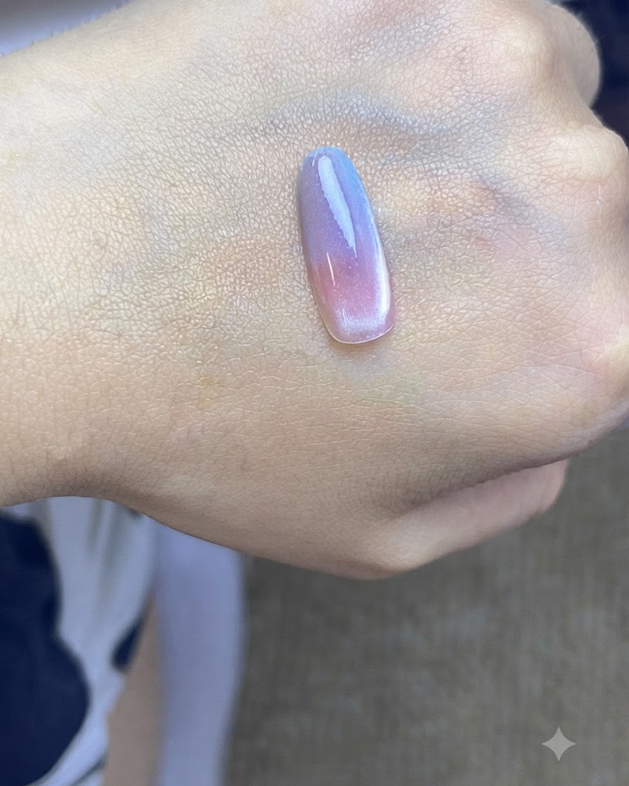 Una punta de uña colocada bajo una lámpara de curado UV tras aplicar la segunda capa de degradado azul.