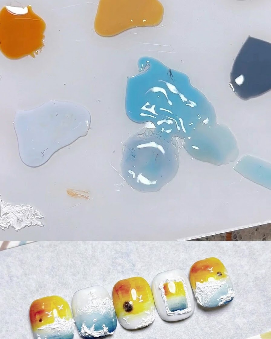 Una paleta de mezcla que muestra gotas de varios colores de gel, incluyendo amarillo pálido, naranja y azul, junto a muestras de arte de uñas.