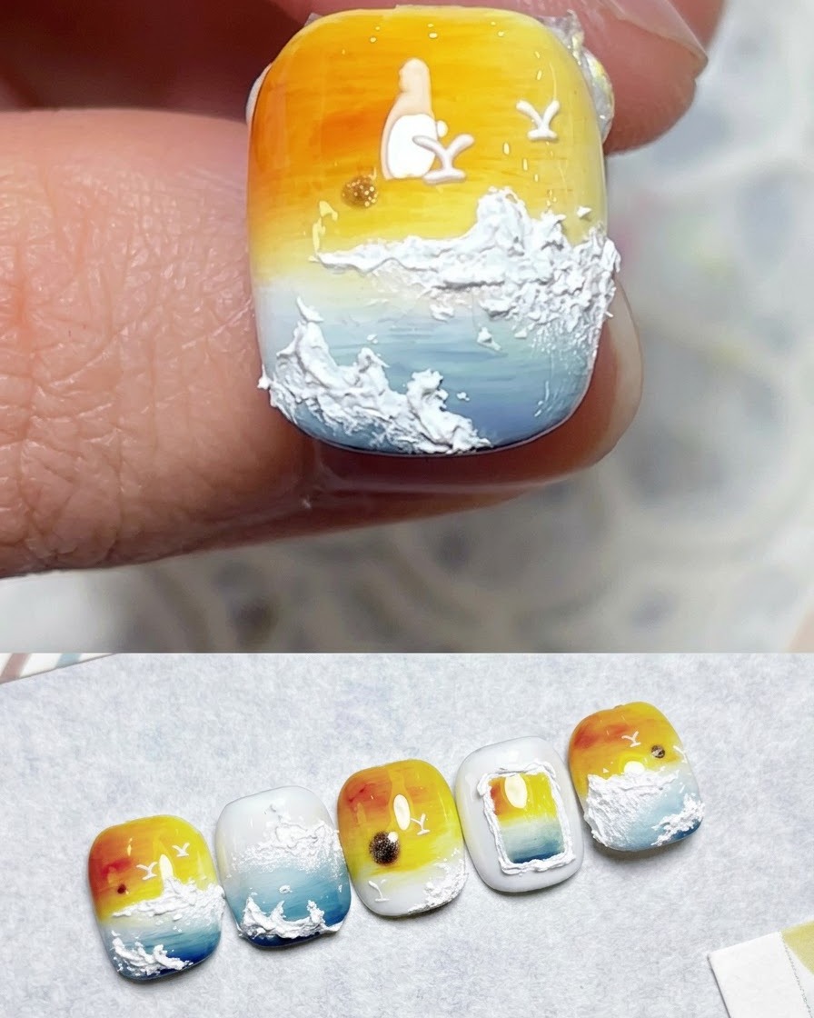 Un pincel aplicando capa superior sobre un diseño de uñas terminadas con degradado de atardecer.