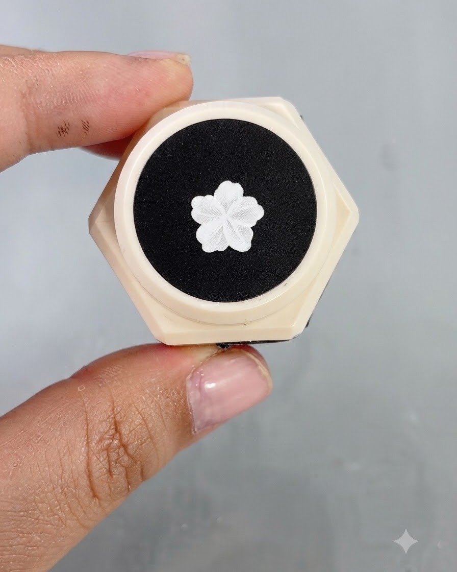 Una toma de cercanía de un pincel delineador fino creando contornos precisos de alas de mariposas blancas y pequeños acentos de estrellas en una uña decorada.