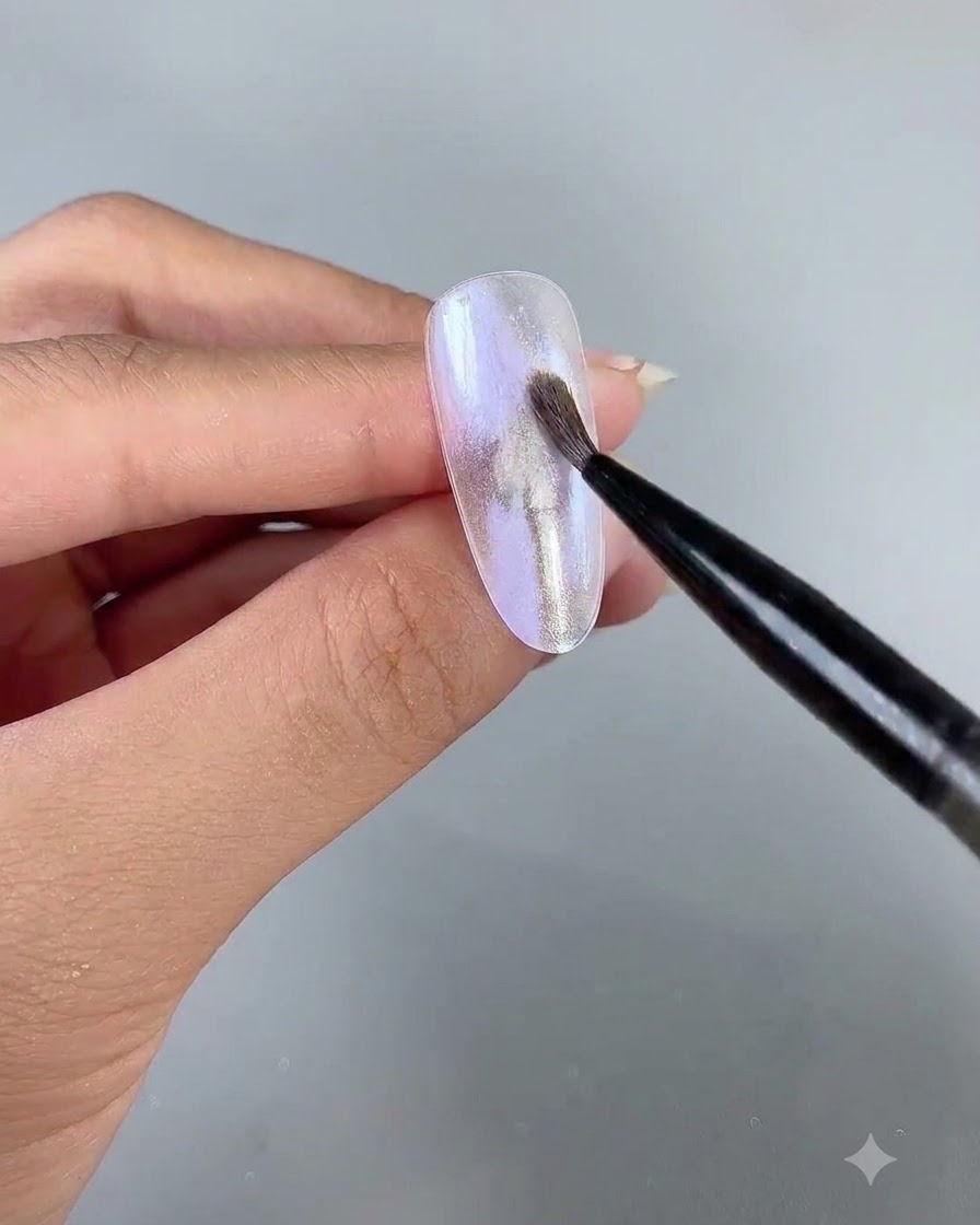Un pincel delineador fino de arte aplicando delicado gel perlado número 3 sobre la superficie de la uña.