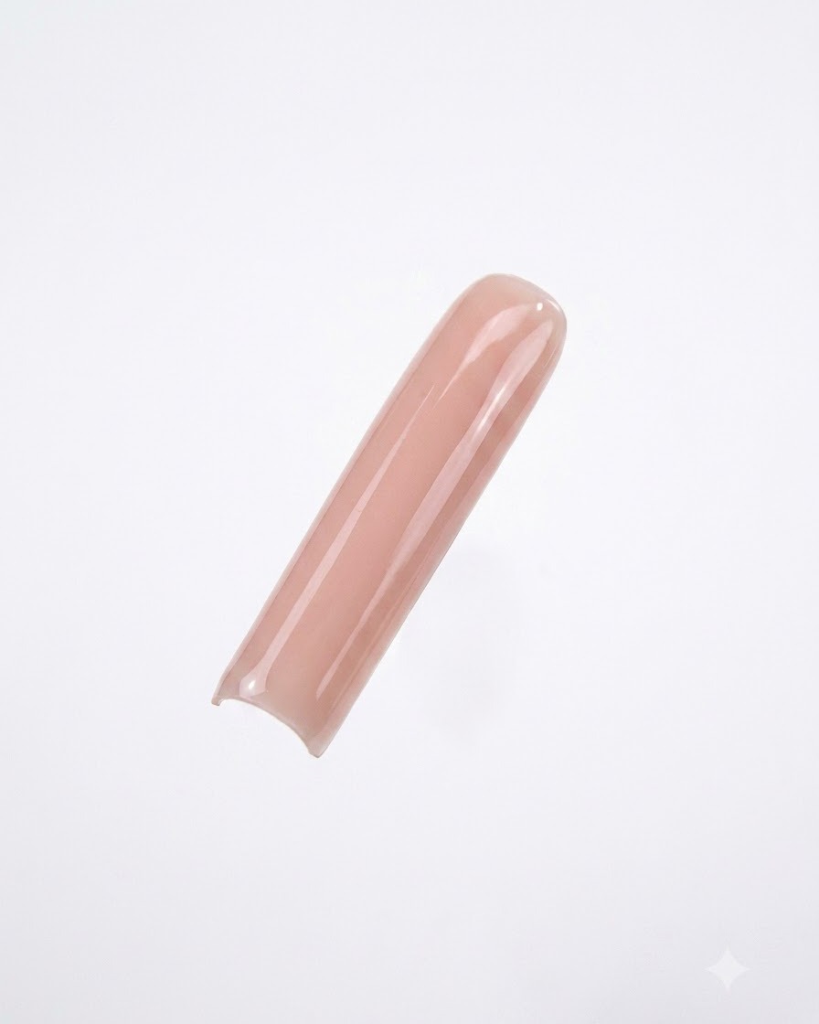 Un tip de uña cuadrada pintado con un esmalte en gel nude suave y opaco sobre un fondo blanco limpio.