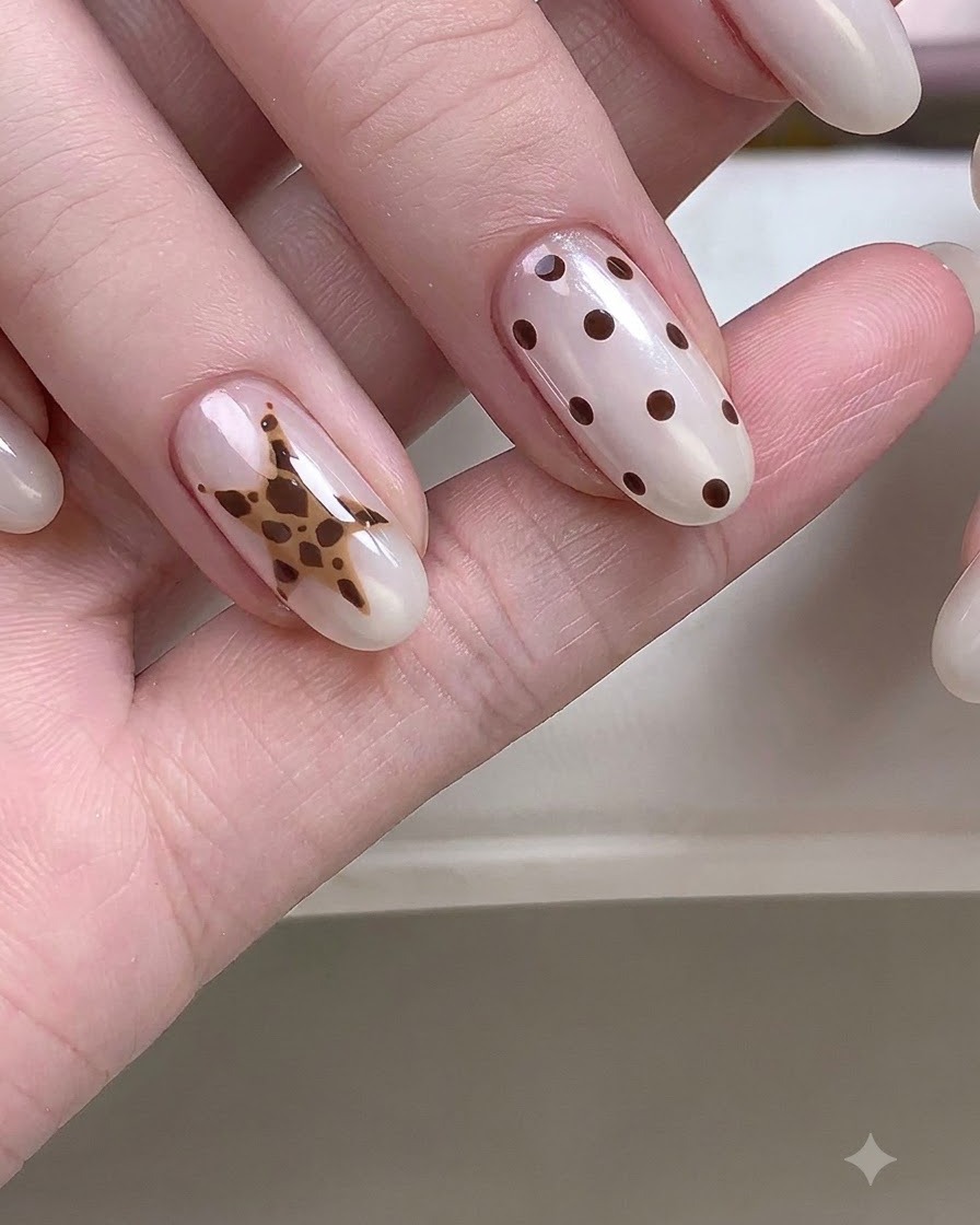 Una mano de cerca que muestra uñas con diseños detallados de estrellas y lunares.