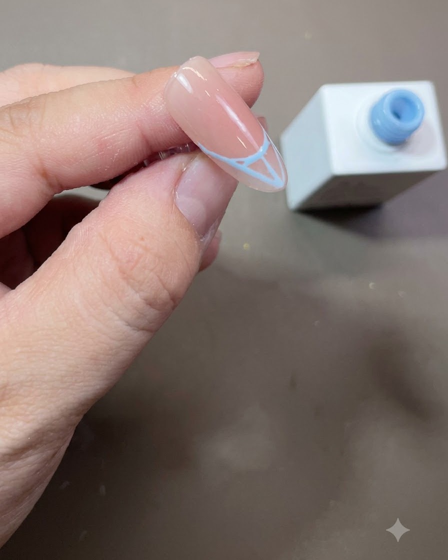 Un contorno de punta francesa azul completado y rellenado sólidamente con esmalte en gel azul en una uña almendrada.