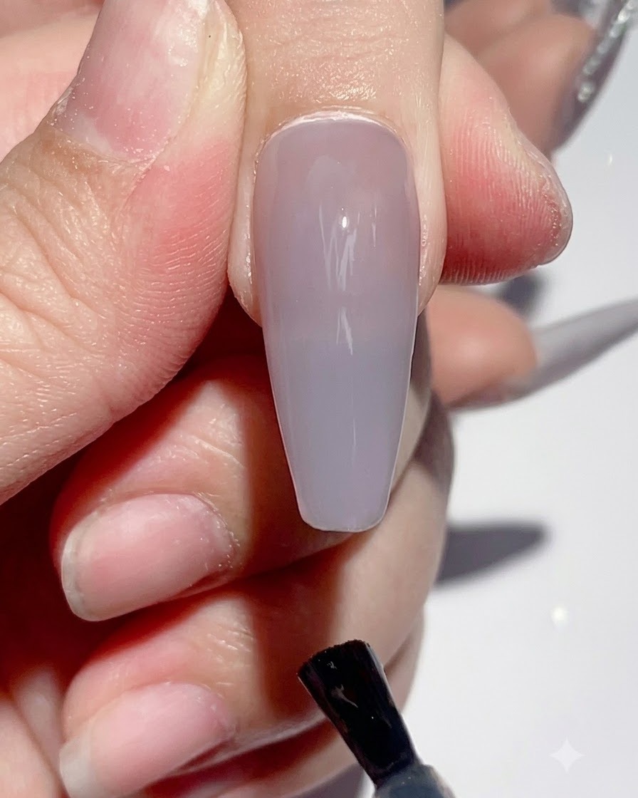 Una mano colocada bajo una lámpara UV LED para uñas durante el proceso de curado.