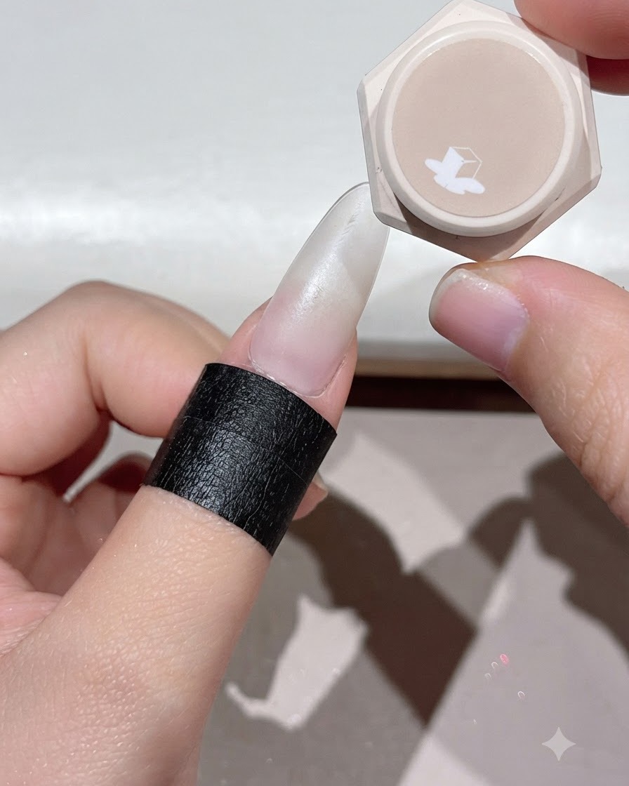 Un dedo colocado bajo una lámpara de uñas UV o LED para curar la capa de gel aplicada.