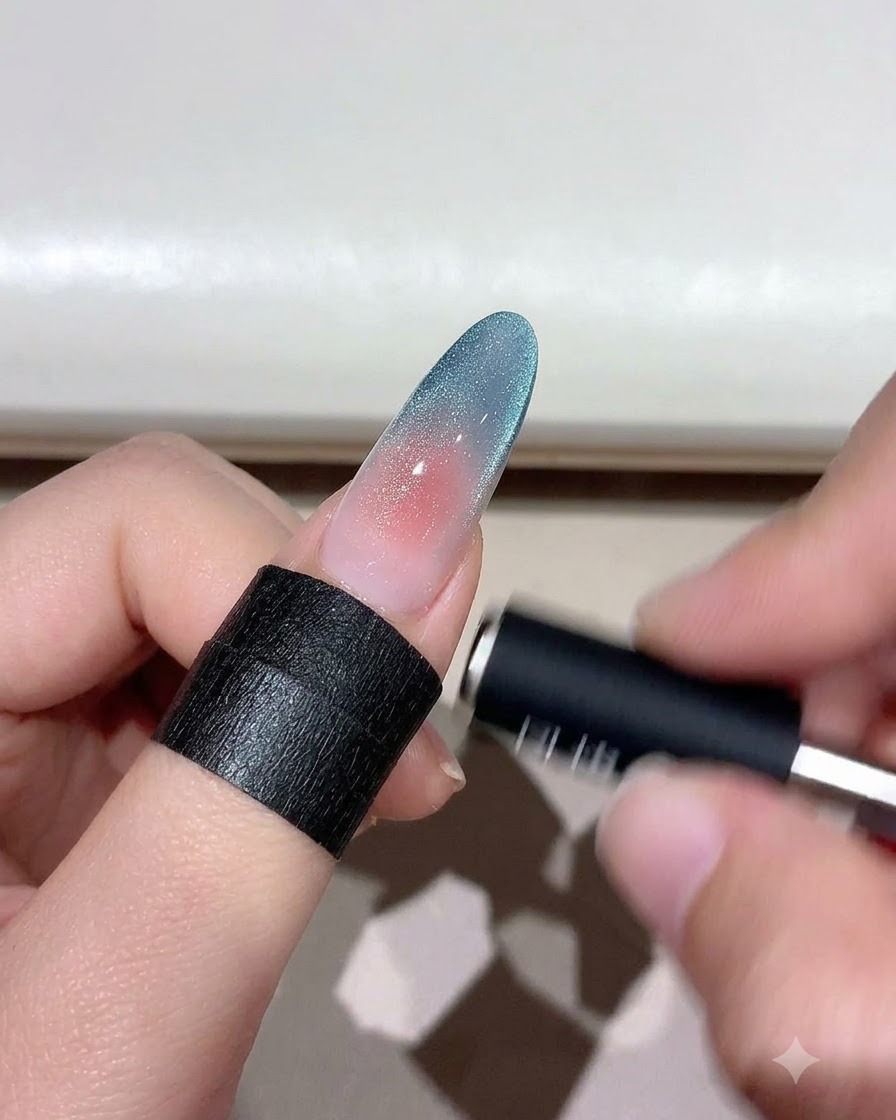 Una herramienta magnética flotando sobre una uña degradada de ojo de gato para dar forma a las partículas de brillo.