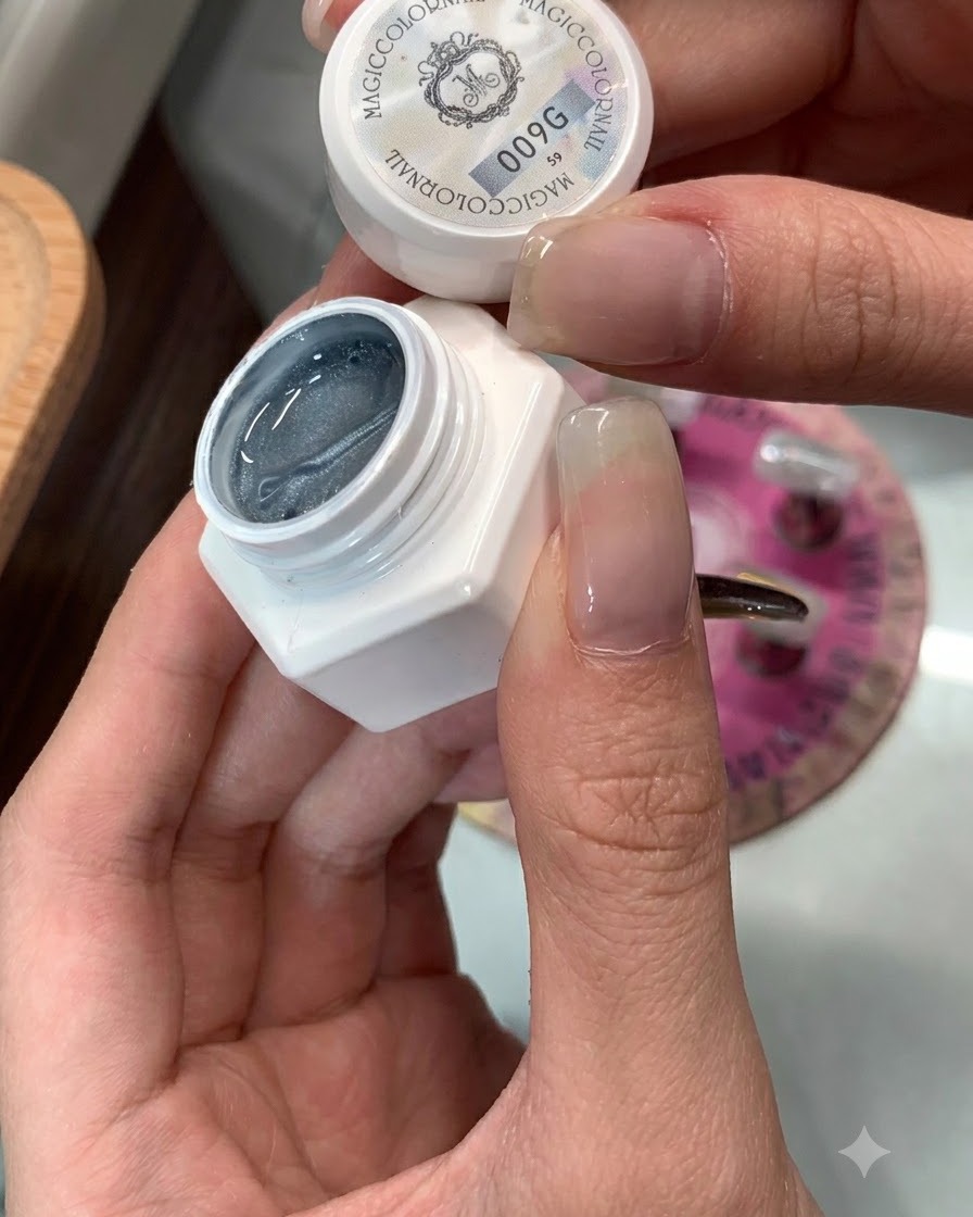 Un frasco de gel ojo de gato 009 al lado de una uña preparada para su aplicación.