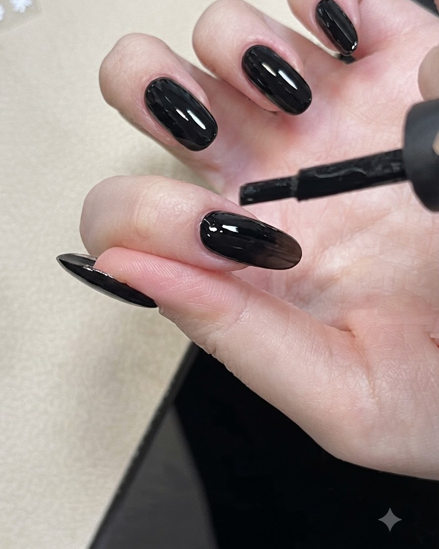 Un pincel de uñas aplicando gel de capa base nude a una uña.