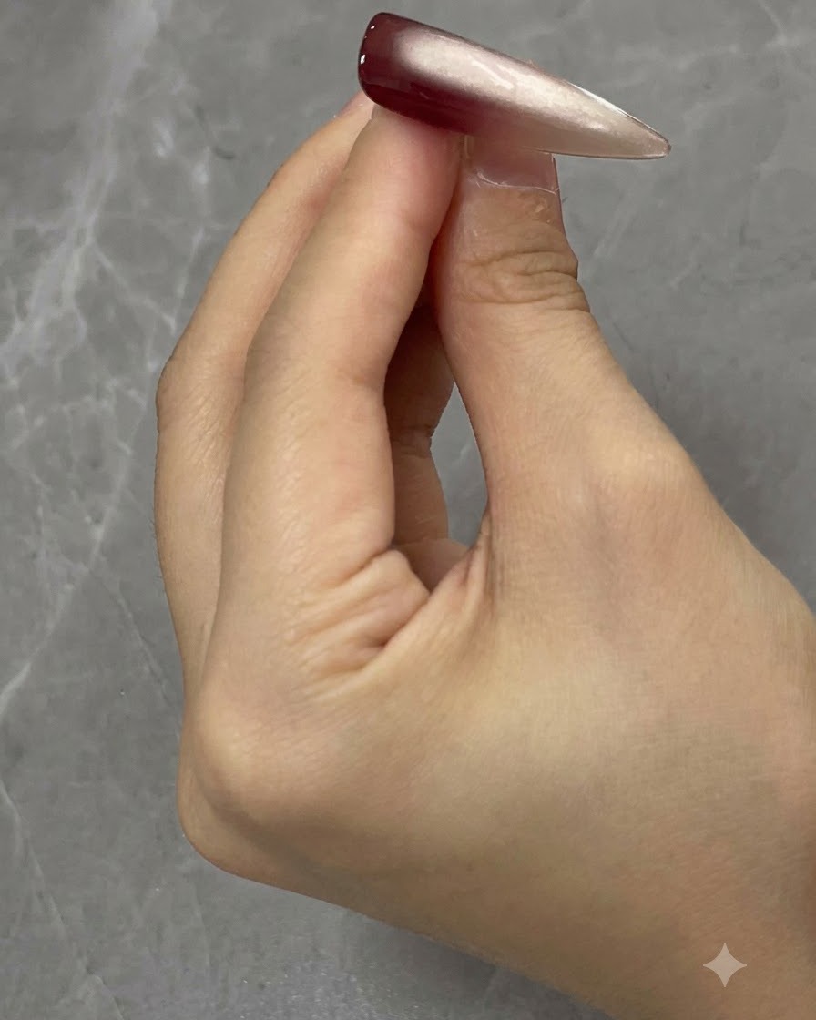 Auftragen einer zweiten Schicht Cat-Eye-Gel auf die Nageloberfläche.