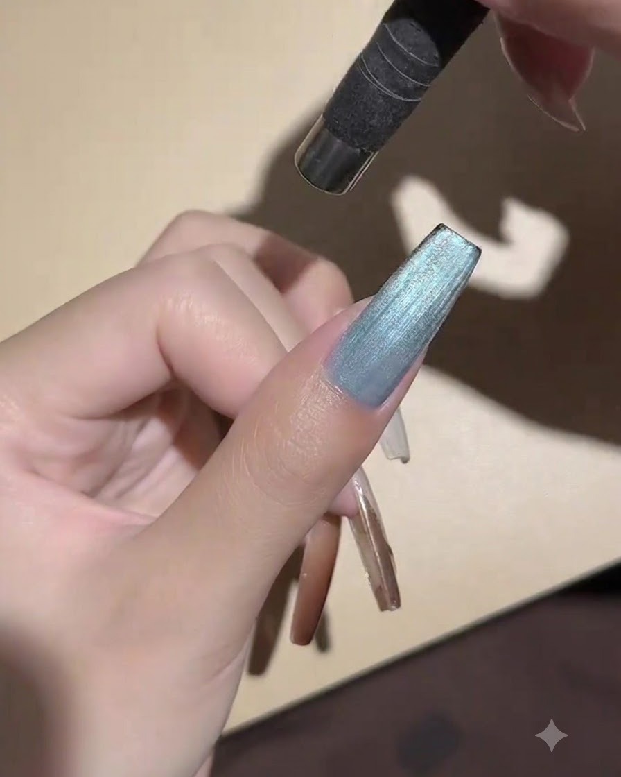 Una mini lámpara UV LED de mano posicionada directamente sobre una uña pintada para curar el gel de ojo de gato.