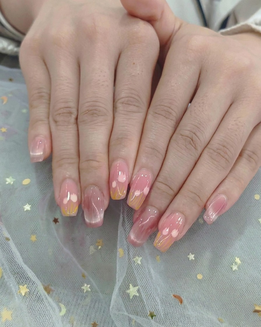 Dos manos colocadas dentro de una lámpara profesional UV/LED curando el esmalte de gel bajo una luz morada brillante.