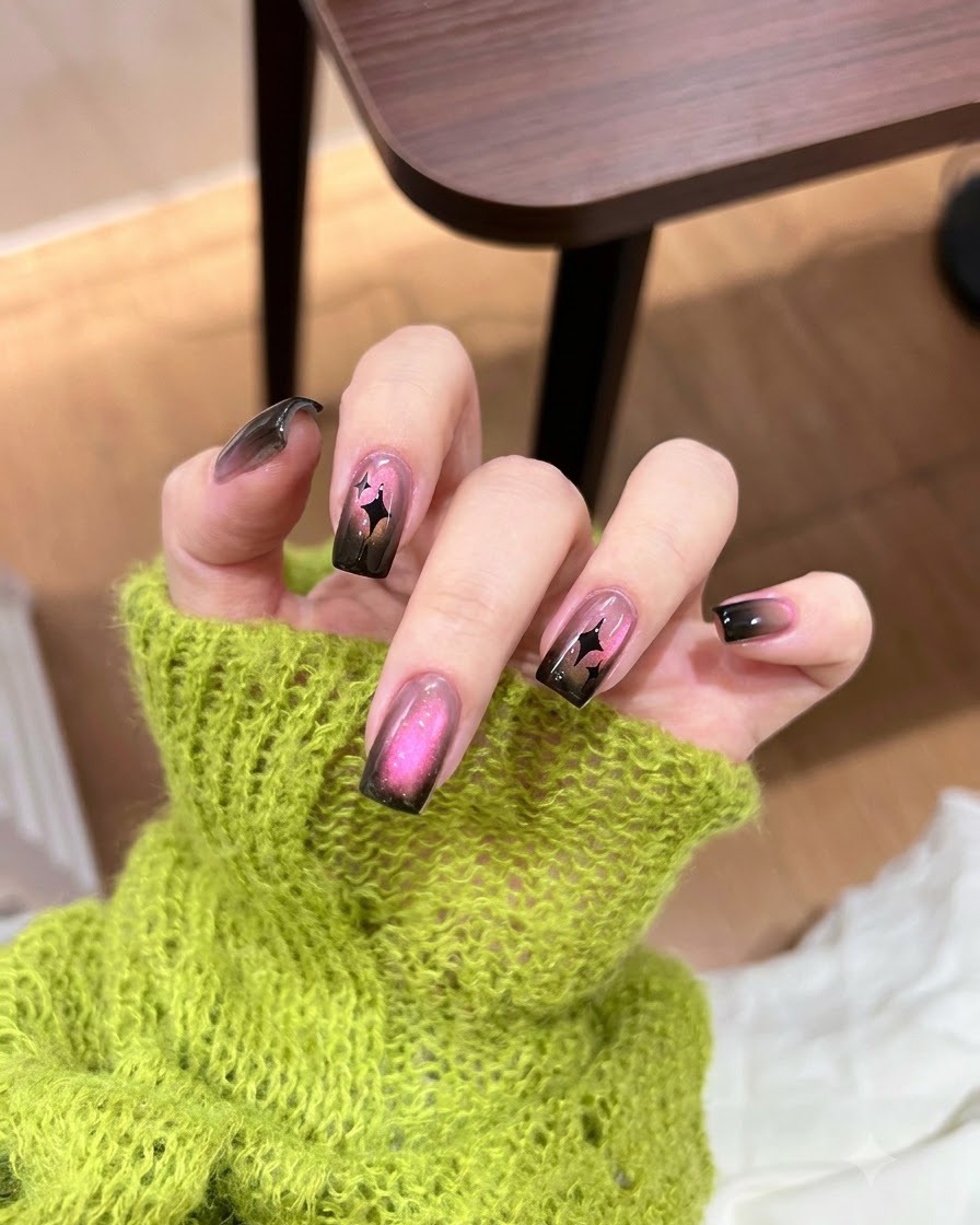 Una pequeña esponja aplicando esmalte de gel negro a toques en la punta de una uña.