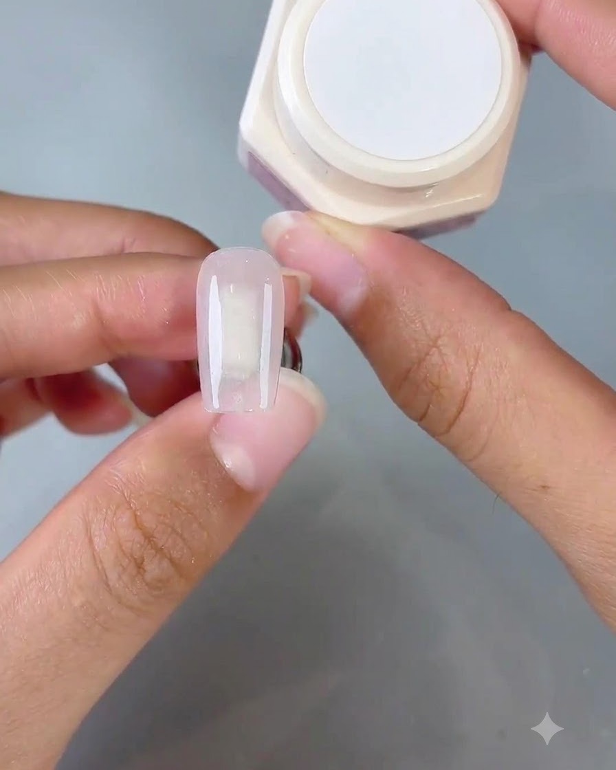 Una herramienta de esponja aplicando gel Gentle No. 1 en la punta de la uña para crear un efecto degradado ombré.