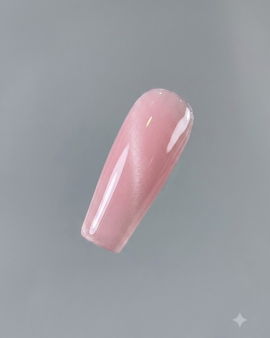 Primer plano de una uña completamente cubierta con gel ojo de gato Aqua Clear No. 2 de tono rosado brillante.