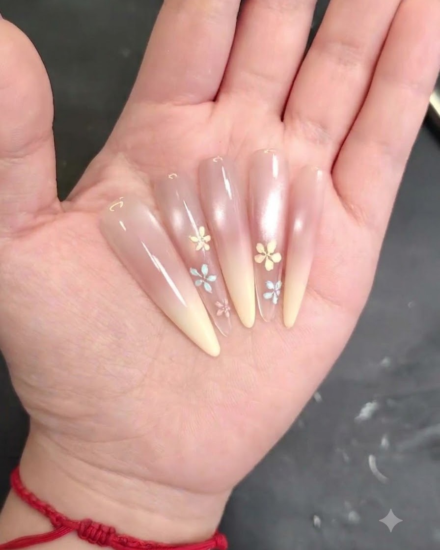 Un pincel de uñas difuminando y suavizando el gel rosa rubor uniformemente sobre la superficie de la uña.