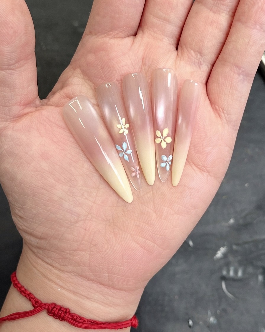 Un pincel aplicando una capa de top coat transparente sobre la superficie de la uña decorada.