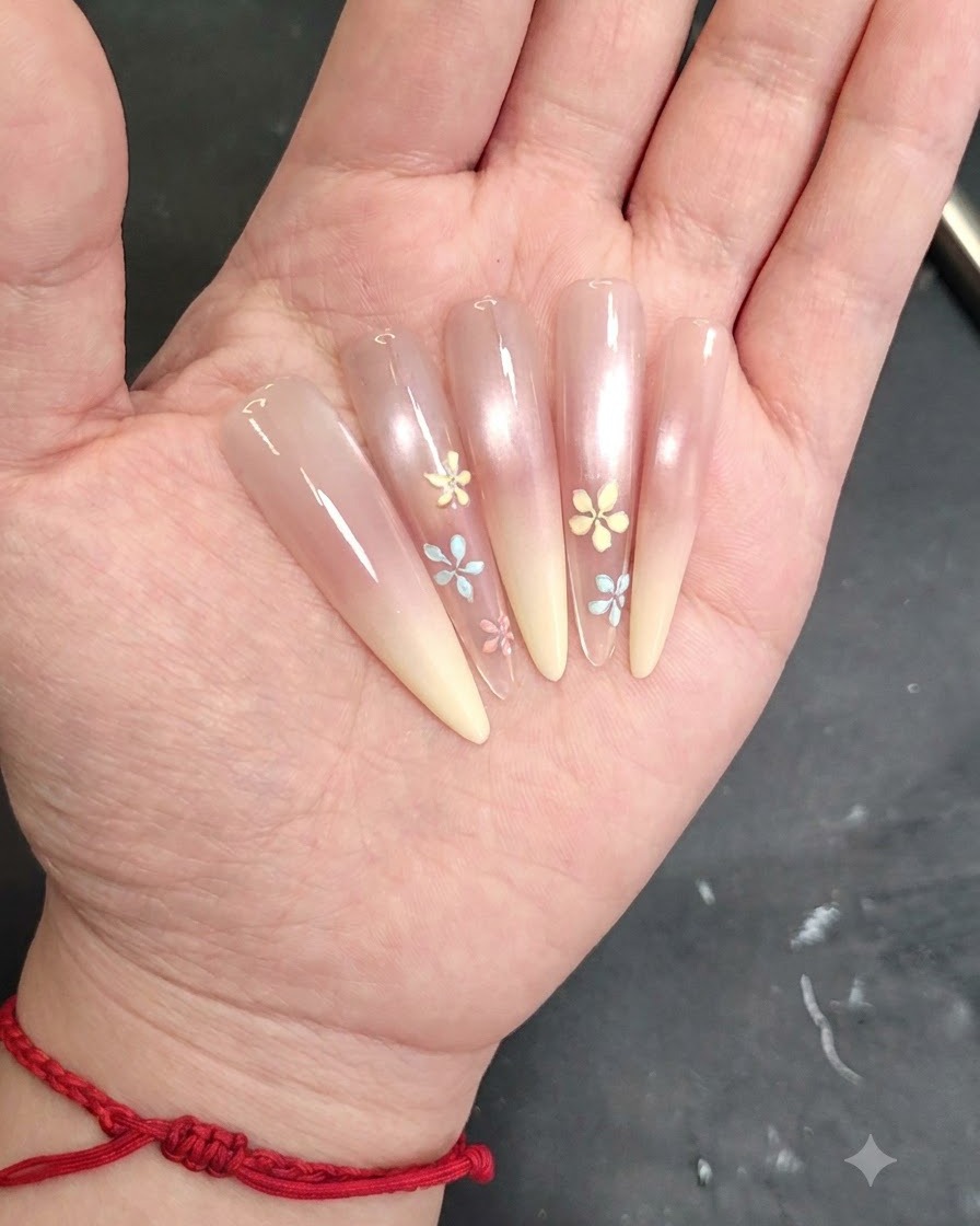 Una toma detallada de un pincel de nail art aplicando un pequeño detalle de pétalo en una uña pintada.