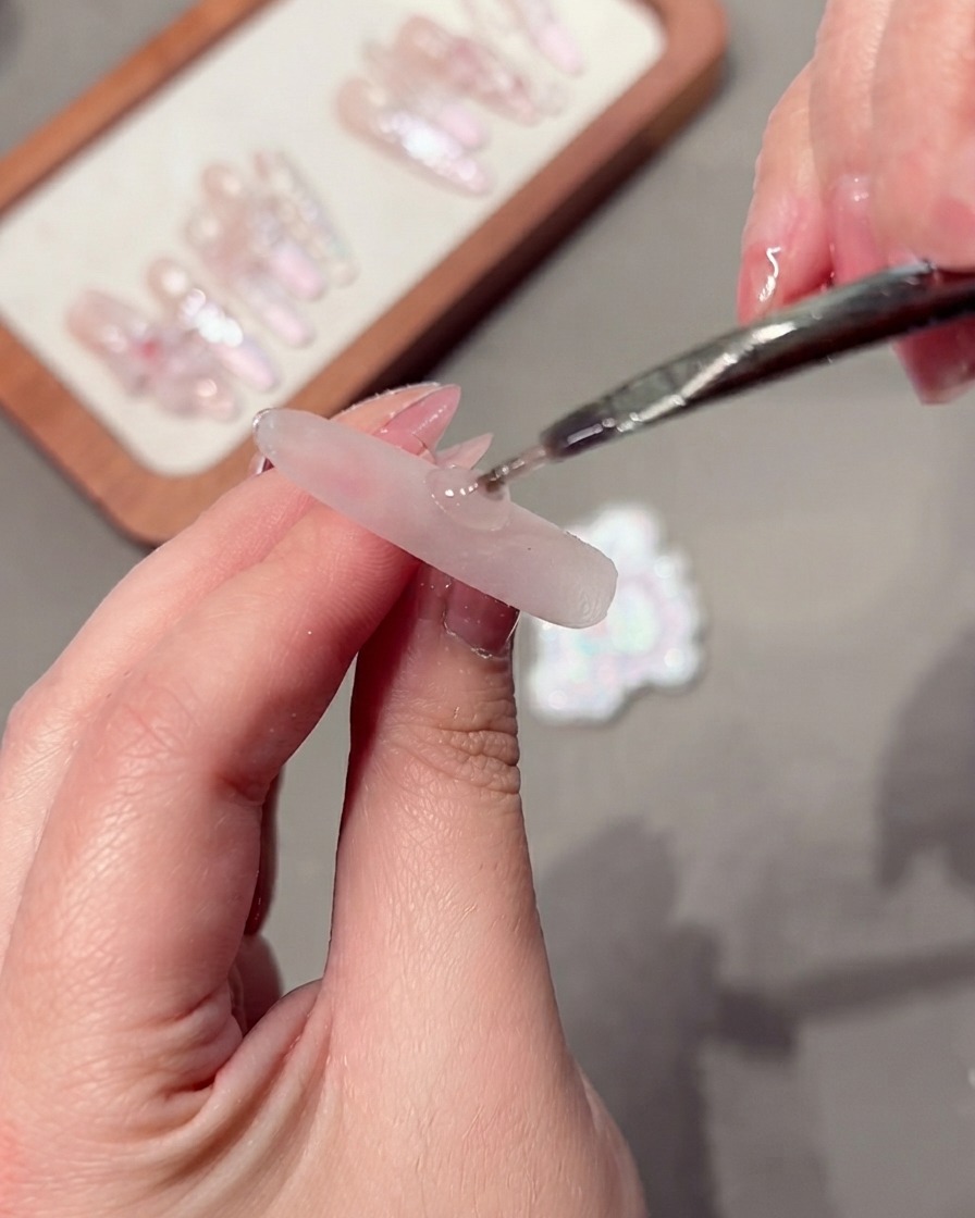 Una herramienta magnética manipulando las partículas del gel ojo de gato en la uña.