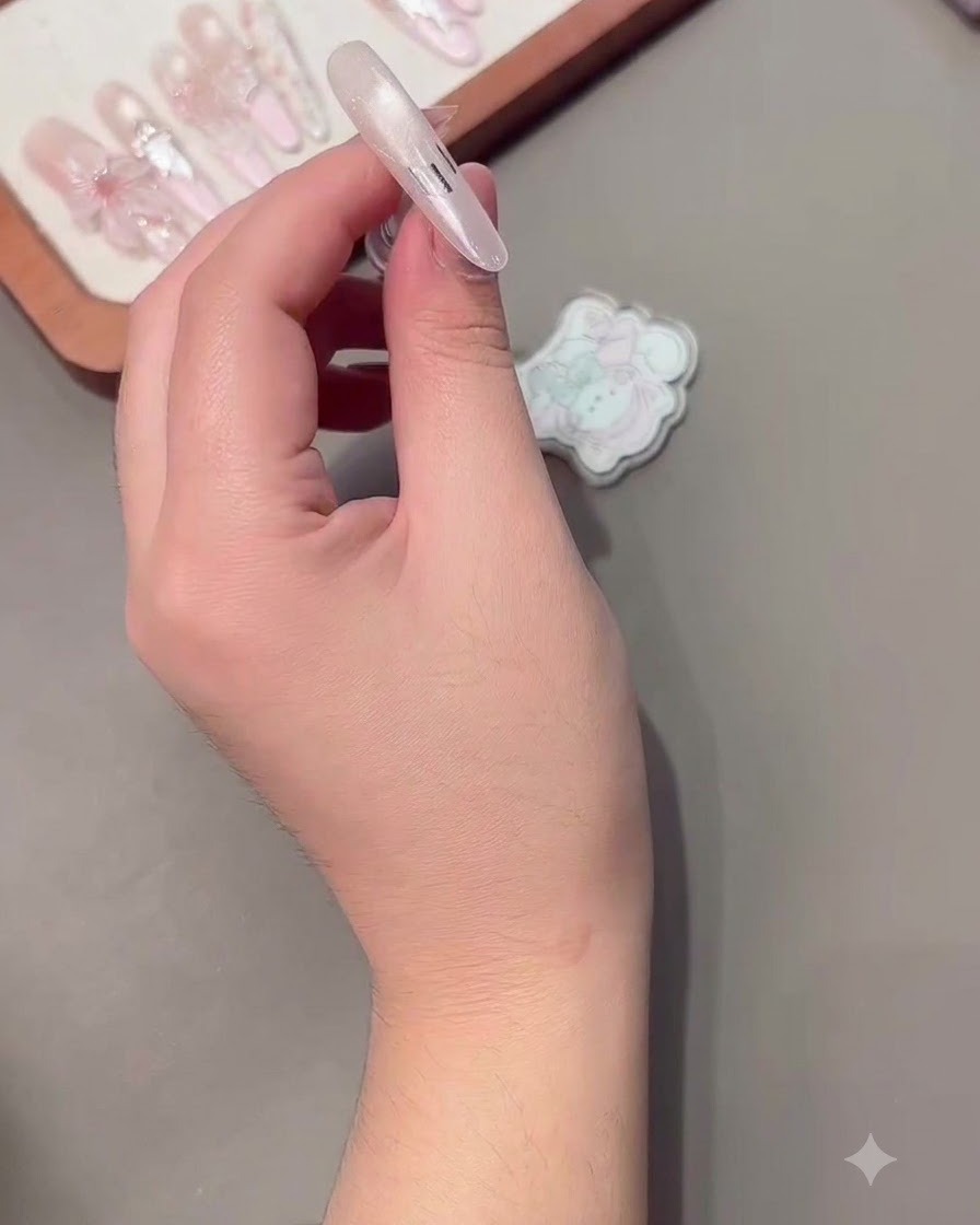 Una pegatina de guía para manicura francesa colocada cuidadosamente sobre la uña.