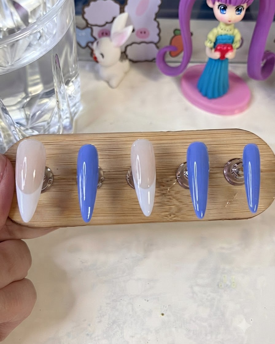 Soportes de uñas con uñas pintadas terminadas colocadas bajo una lámpara de curado UV y LED.