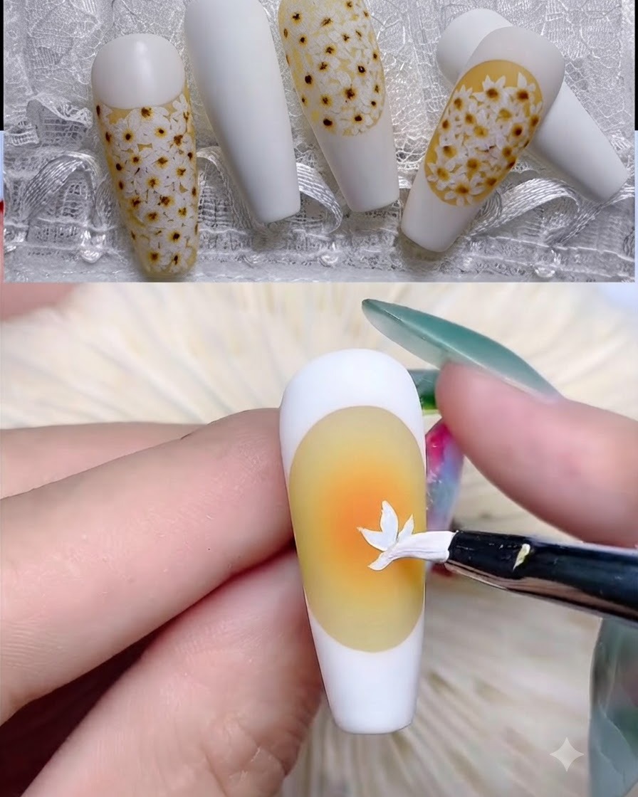 Un pincel delineador fino dibujando el borde blanco de una manicura francesa sobre una uña con base amarilla.