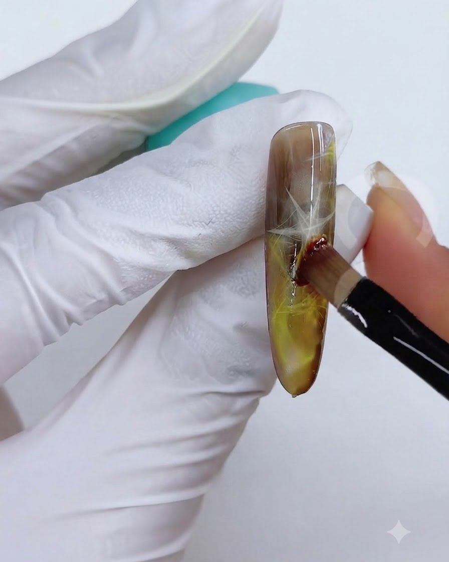 Una técnica de pincel y esponja utilizada para difuminar el color amarillo-marrón en la superficie de la uña.
