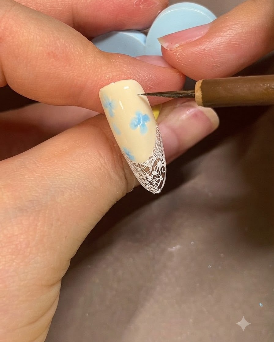 Un pincel aplicando gel constructor transparente sobre una uña decorada para suavizar y proteger el diseño.
