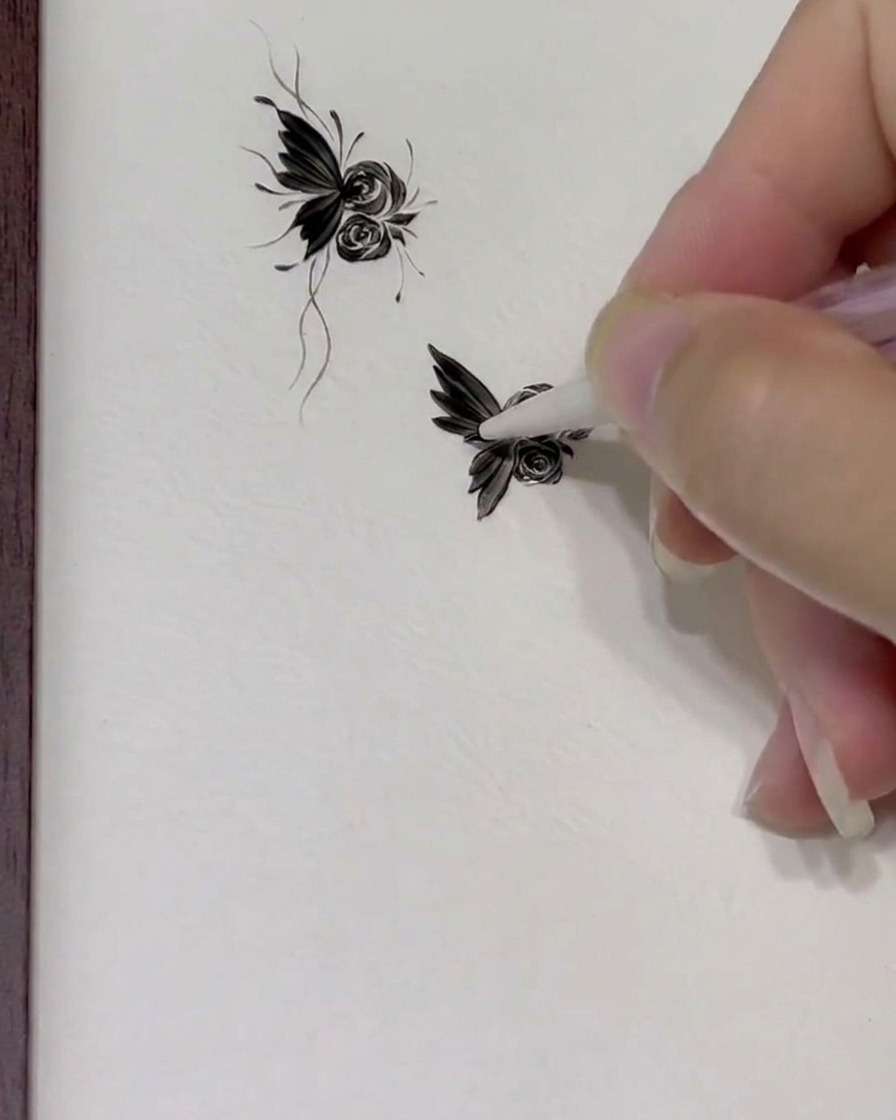 Una vista de cerca de un pincel de nail art aplicando puntos de gel precisos y líneas finas limpias sobre un diseño floral de mariposa.
