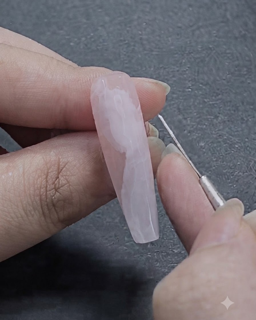 Un pincel delineador fino de nail art dibujando delicadas líneas blancas sobre el diseño de cinta de gel semi-difuminado.