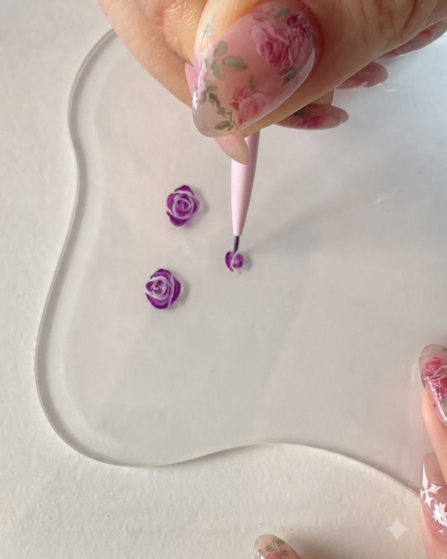 Un pincel delineador fino añadiendo líneas de pétalos exteriores fluidas para desarrollar aún más la forma de la rosa morada.